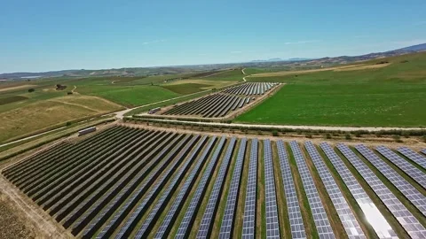 Drone flying over solar panels surrounded by green fields, Sicily, 4K Stock Footage 288541244