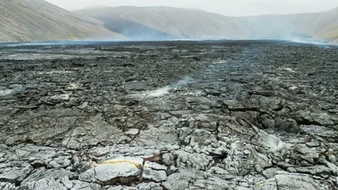 Drone flying over steaming hot lava rocks still cooling down near Geldingadalir Stock Footage 233034507