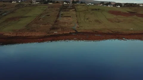Drone flying over still calm reflective lake during sunrise in Isle of Skye Stock Footage 167732704