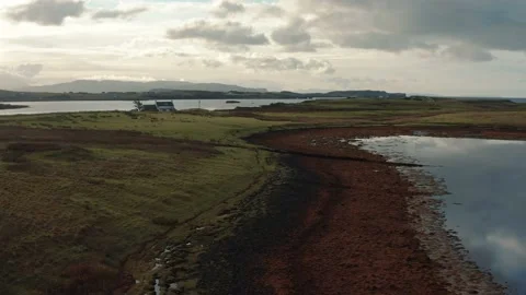 Drone flying over still calm reflective lake during sunrise in Isle of Skye Stock Footage 167732722