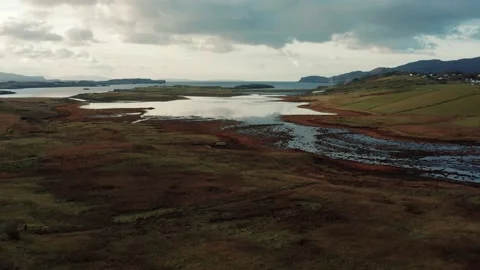 Drone flying over still calm reflective lake during sunrise in Isle of Skye Stock Footage 167732766