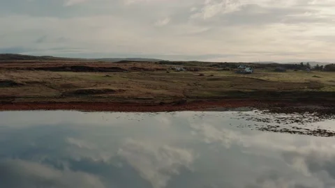 Drone flying over still calm reflective lake during sunrise in Isle of Skye Stock Footage 167732859