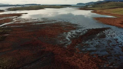 Drone flying over still calm reflective lake during sunrise in Isle of Skye Stock Footage 167732942