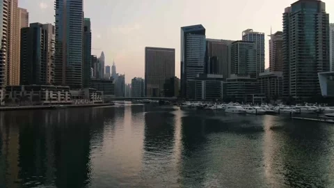 Drone is flying over the surface of Dubai Creek, docks with luxury yachts, 4k Stock Footage 152885872