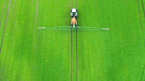 Drone flying over a tractor fertilizing a green field 4K Video stock 236723377