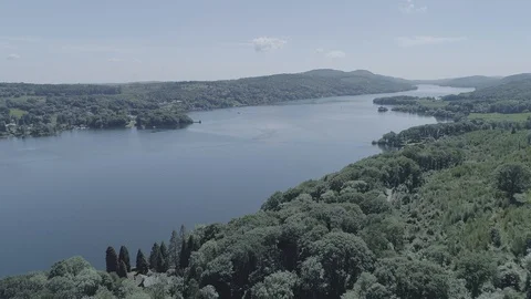 Drone Flying over trees and rising to show Windermere lake - DLog Stock Footage 90912466