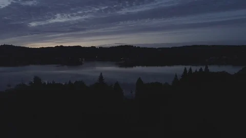Drone Flying over trees to a gap revealing boats on lake windermere - DLog Stock Footage 90906594