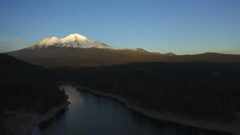 Drone flying over water looking over Mt. Shasta in the Oregon forest Stock Footage 145859095