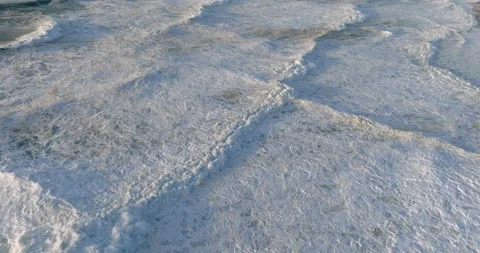 Drone flying over the white foam and waves near the sandy sea coastline. Tide Stock Footage 223425592