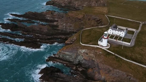Drone flying over a white lighthouse and rocks, ocean view, Ireland Stock-Footage 267076784