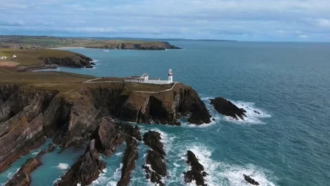 Drone flying over a white lighthouse and rocks, ocean view, Ireland Stock Footage 267079742