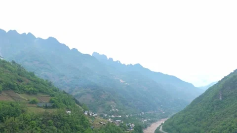 Drone flying over a winding river nestled in the heart of the mountains. Stock Footage 310883075