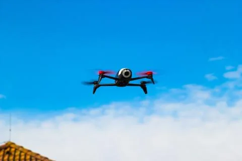 Drone flying overhead in cloudy blue sky Foto stock