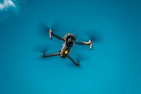 Drone flying overhead in cloudy blue sky Stock Photos