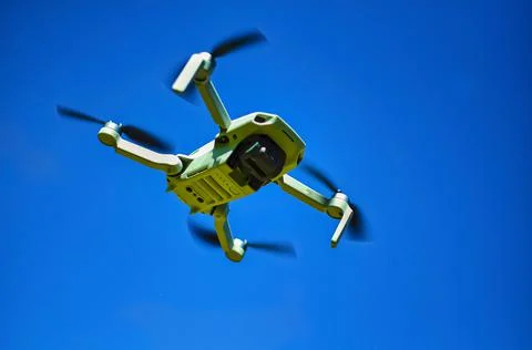 Drone flying overhead in cloudy blue sky Stock Photos