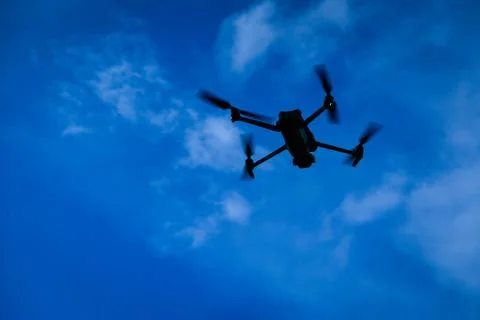 Drone flying overhead in cloudy blue sky Stock-Fotos