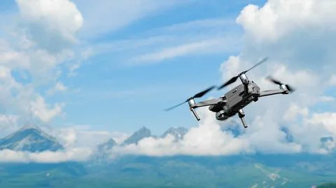 Drone flying overhead in a high cloudy sky with High Tatra mountains on the Stock Photos