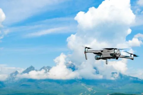 Drone flying overhead in a high cloudy sky with High Tatra mountains on the Stock Photos