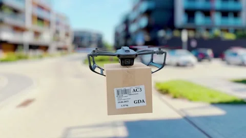 The drone is flying with a package to the customer through a modern residen.. 스톡 동영상 243111033