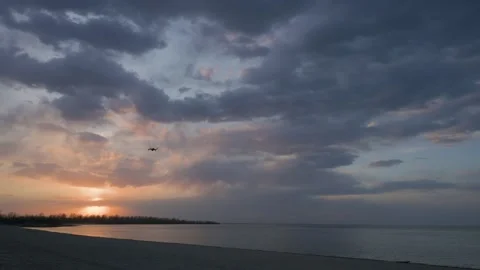 A drone flying past the camera and into an evening sky full of clouds Stock Footage 154046800