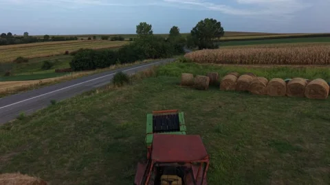 Drone flying past old tractor beside corn field Stock Footage 344358914