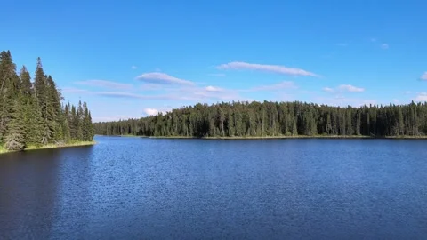 Drone flying quickly and low above a calm large northern lake.  Stock Footage 276281138