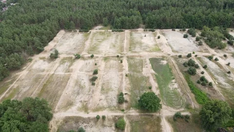 Drone Flying Right to Left Over Dry Land by the Forest, Revealing a Village Stock Footage 314294573