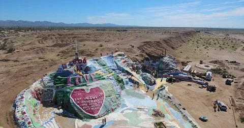 Drone flying up to Salvation Mt. at Slab City, California Stock Footage 73523614