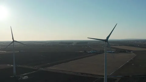 Drone flying at the same height as the axis of some huge wind turbines Stockbeeldmateriaal 153415543