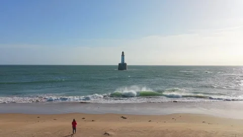 Drone flying from sandy beach towards rattray head lighthouse 库存影片 334057866