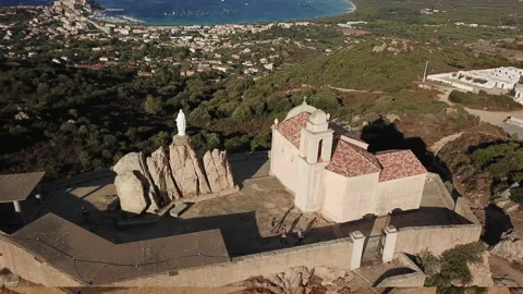 Drone flying sideway behind the madonna della sierra church in Calvi, France Stock Footage 164704831