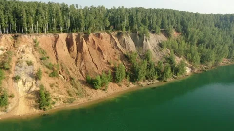Drone flying sideways along forested cliff Stock Footage 324245705