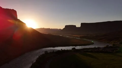 Drone flying sideways exposing the sunrise at the Colorado river in Moab in 4k Stock Footage 338195136