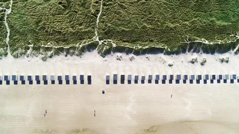 Drone flying sideways over beach with long row of beach huts Stock Footage 298650214