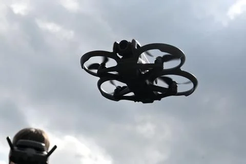 Drone is flying in the sky. Operator controls the drone Stock Photos