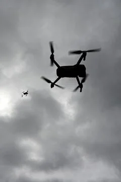 Drone is flying in the sky. Operator controls the drone. Stock Photos