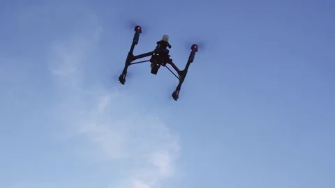 Drone Flying In The Sky In Slow Motion Pan To Two Pilots Remote Controlling It Stock Footage 82589831