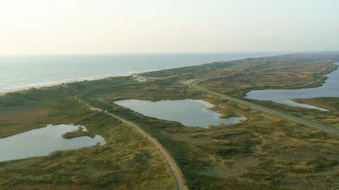 Drone flying slowly backwards over marshland on the Danish west coast Stock Footage 272293335