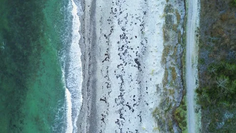 Drone flying slowly backwards over desolate beach on a winter morning Stock Footage 287915446