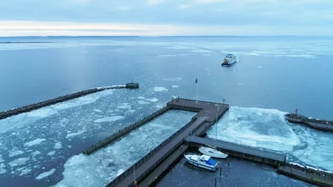 Drone flying slowly backwards over ice packed boat marina in Denmark Stock Footage 287915461