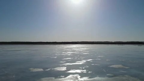 Drone flying slowly forward over a frozen lake with puddles of water Stock Footage 151707773