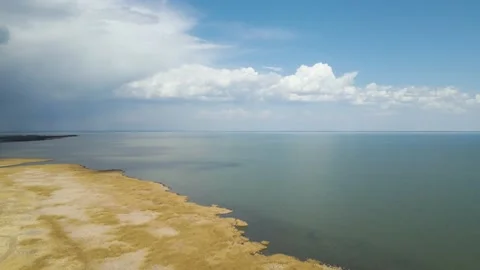 Drone flying slowly forward over a large lake with a marshy shore.  Stock Footage 154121449