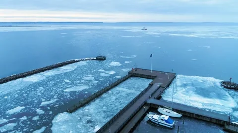 Drone flying slowly forward over ice packed boat marina in Denmark Stock Footage 287915485