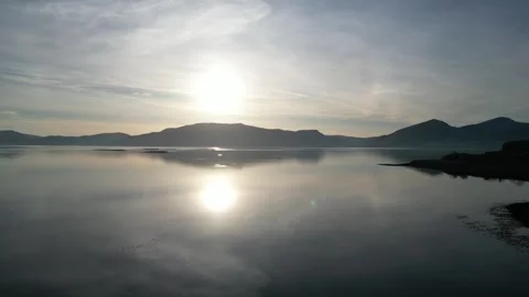 Drone flying slowly forward over lake at sunset in Scotland 動画素材 334458969