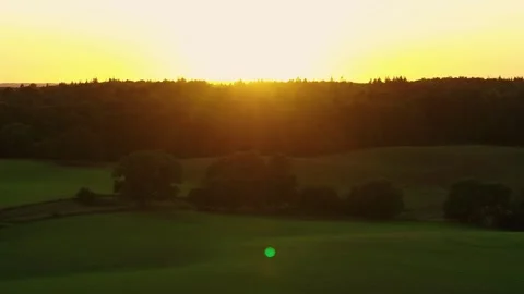 Drone flying slowly over beautiful meadow towards the sunset Stock Footage 298650345