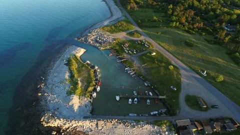 Drone flying slowly over tiny marina with dinghy and row boats Stock Footage 298651060