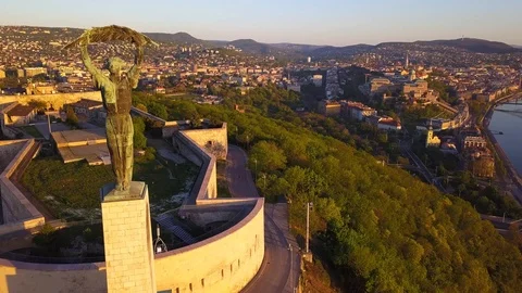 Drone flying up at Statue of Liberty and Citadel on Gellert Hill at sunrise Stock Footage 88908575