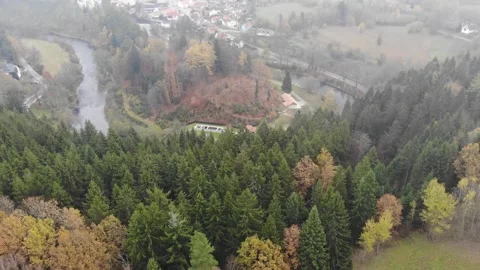 Drone flying through the clouds over the autumn forest and river Stock Footage 257875653