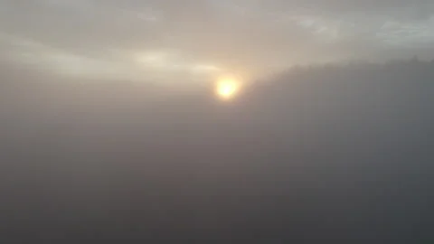 Drone flying through clouds over forest at sunrise, cinematic alpine landscape Stock Footage 325021351