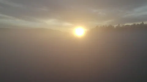 Drone flying through clouds over forest at sunrise, cinematic alpine landscape Stock Footage 325021587